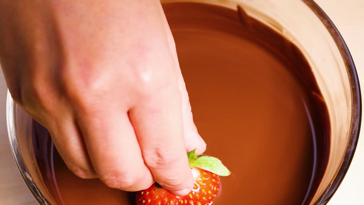 녹은 초콜릿 에 딸기 를 담그고 있는 것