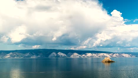 white clouds float above the smooth lake