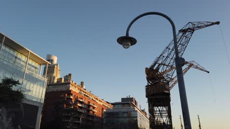 old crane in a city port at sunset