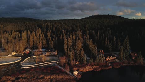 sensacional toma de distancia de un rancho en el lago de vislumbre durante la puesta de sol, en un bosque de pinos