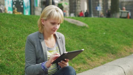 Young-Woman-Resting-In-The-Park-Enjoys-A-Digital-Tablet-4k-Video