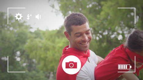 Taking-photos-of-father-and-daughter-in-garden-on-a-digital-camera