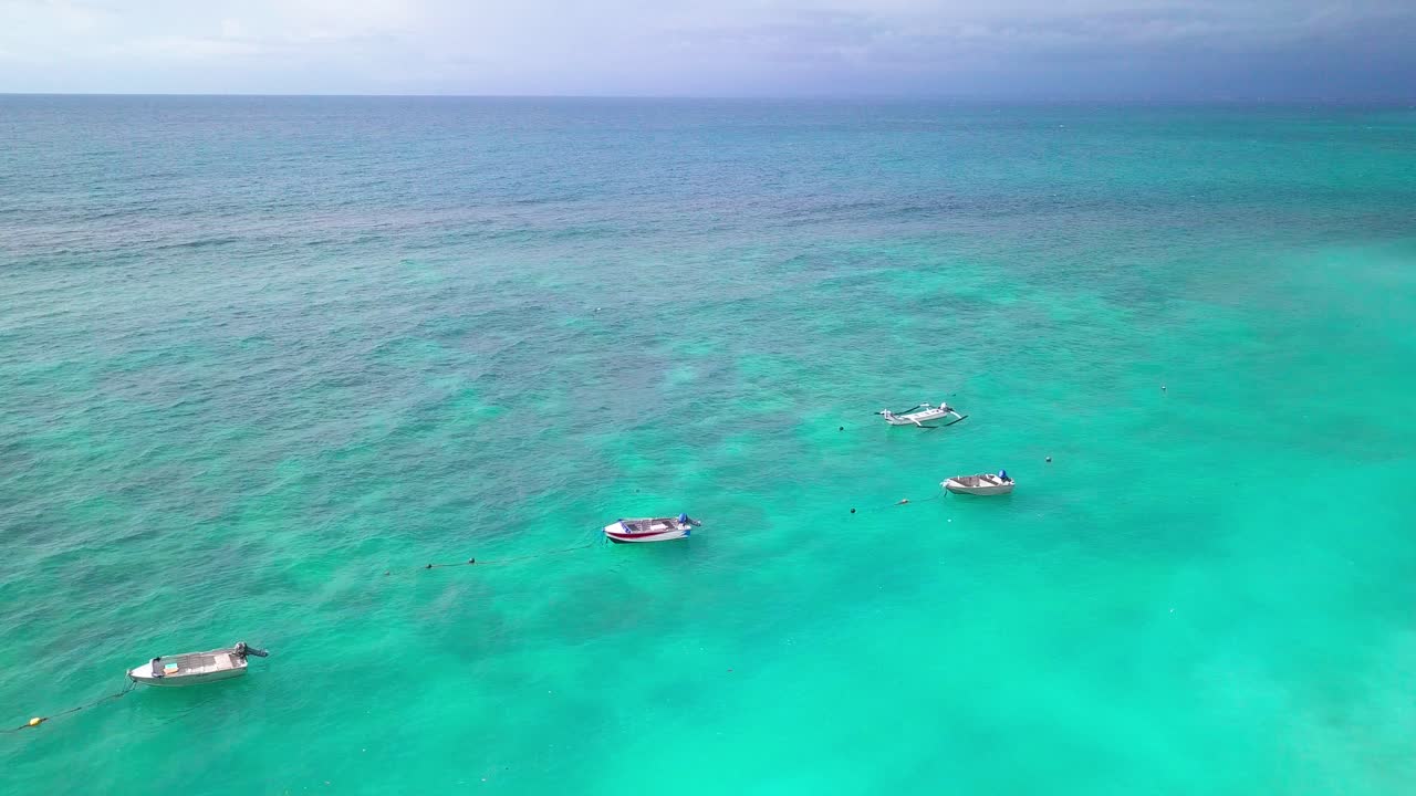 Drone video of a blue sea in Bali with 4 boats floating Uluwatu Indonesia