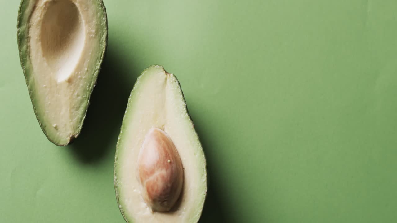 Video di avocado affettato con spazio per il testo su sfondo verde