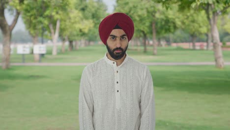 guilty sikh indian man hiding his face in park