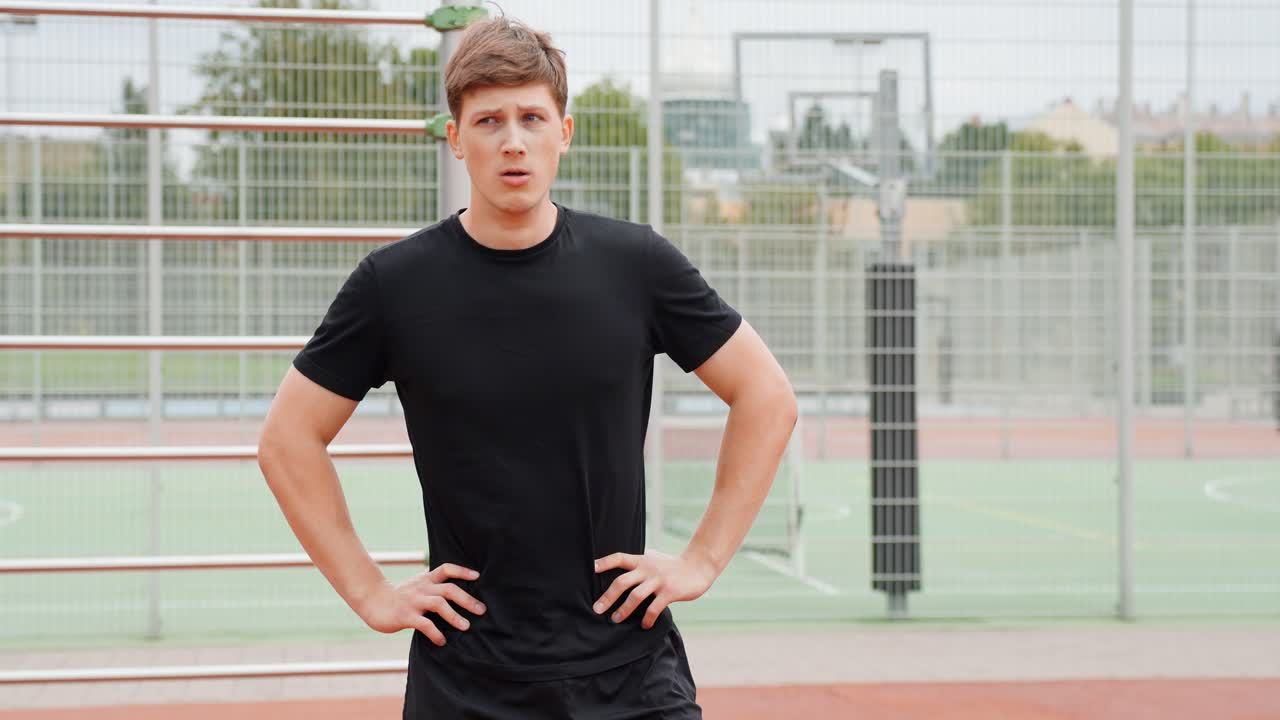 Man Breathing Hard With His Hands On His Hips After An Intense Outdoor Workout. - medium shot