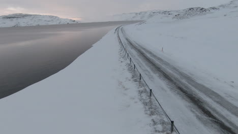 fast fpv, dolly forward above frozen country road