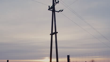 wide shot of an electricity pylon at sunrise