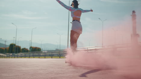 woman skateboarding with pink smoke