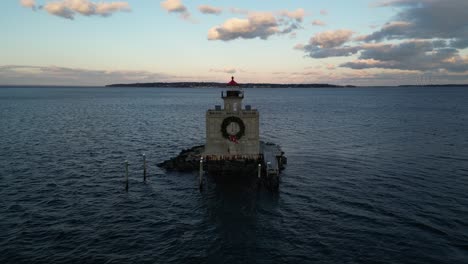 an aerial view of the huntington harbor lighthouse on long island, ny at sunset, with a christmas wreath