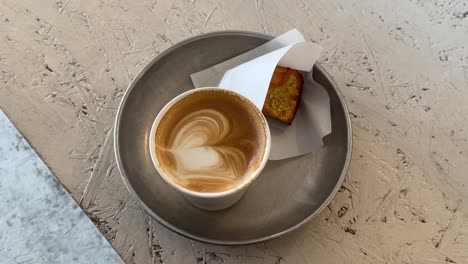 a handcrafted latte beside a delicate pastry sits untouched on a café table in kyoto, embodying a peaceful and inviting mid-morning atmosphere.