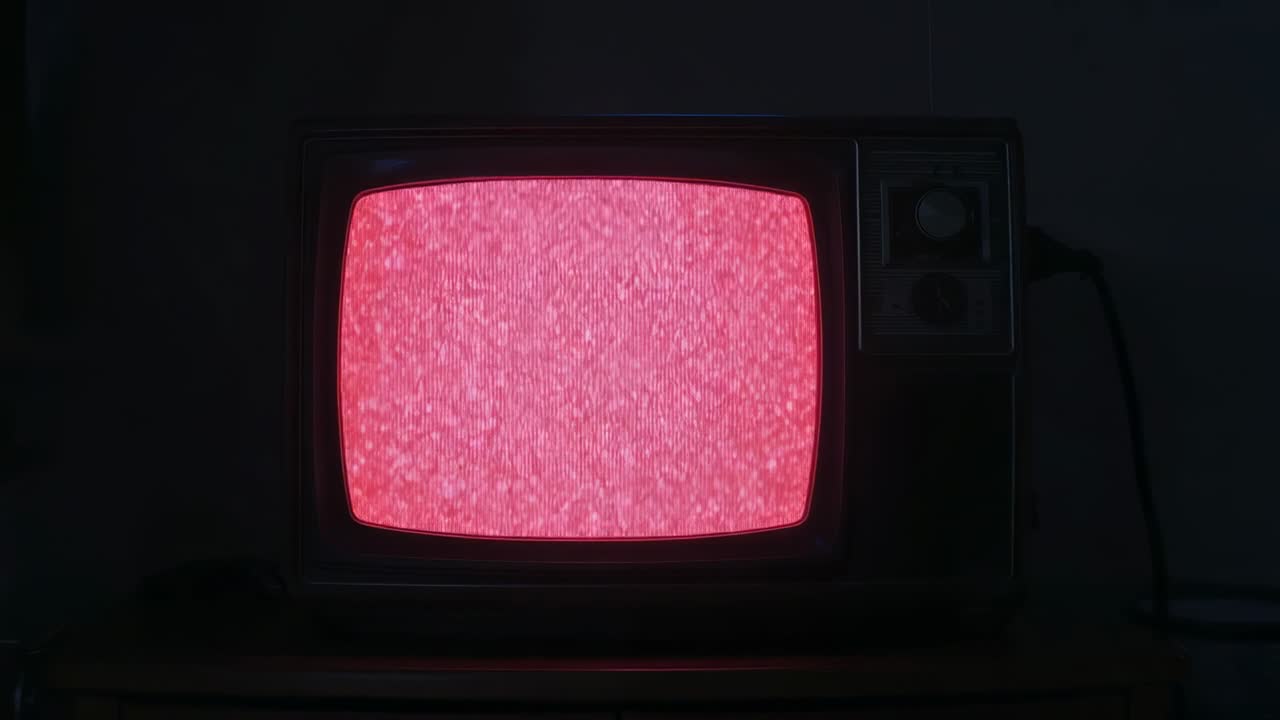 Powering CRT television showing flickering static shifting blue to pink to red on wooden cabinet