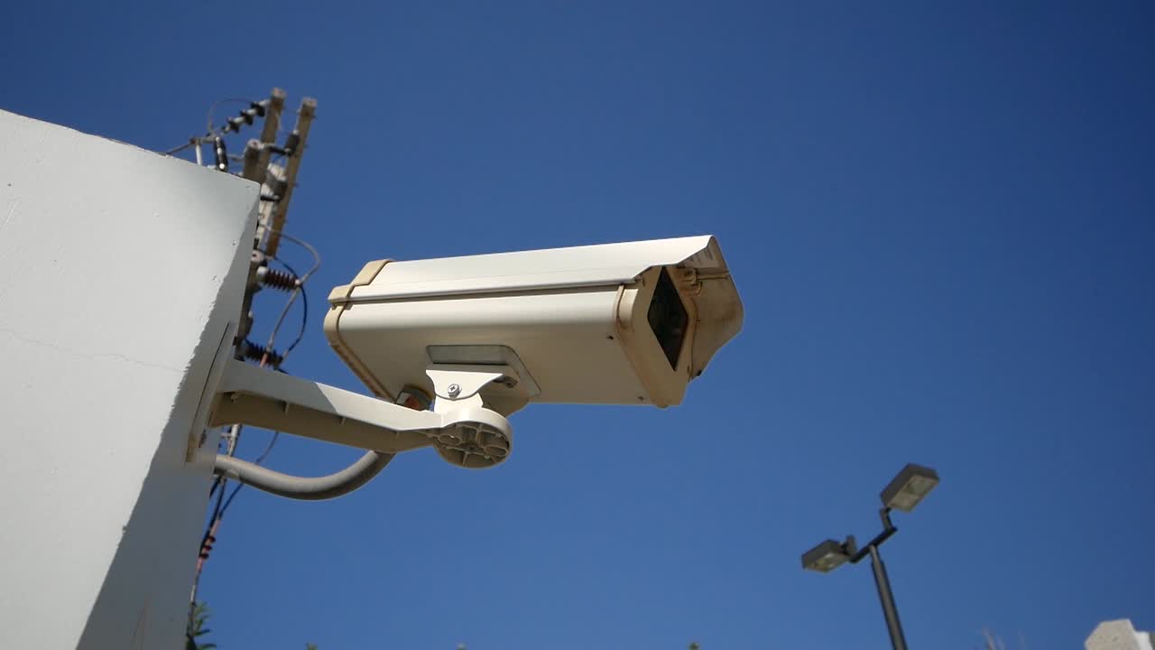 cámara de vigilancia blanca de primer plano con cielo azul de fondo