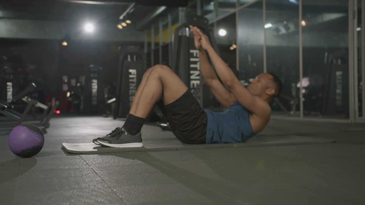 체육관에서 육체적인 아프리카계 미국인 남자의 측면 시각.