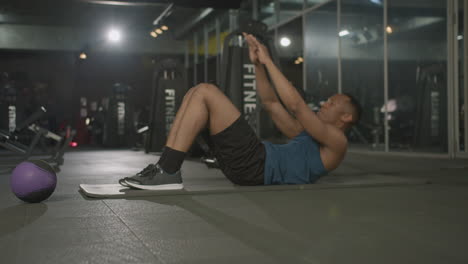 Side-view-of-an-athletic-african-american-man-in-the-gym.