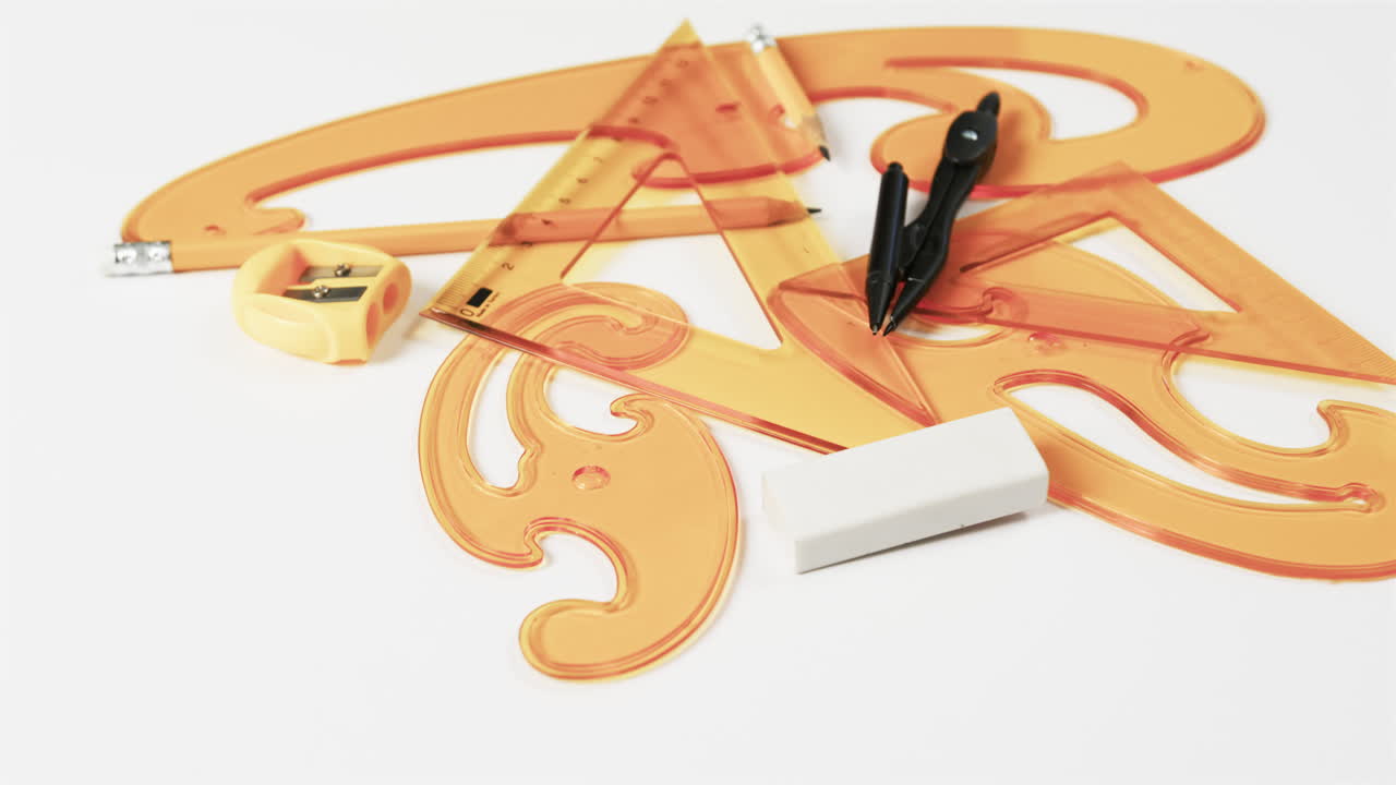 ⁇ 색 배경 에 있는 나침반, 연필, 날카롭기, 지우기, 선형자 의 클로즈업, 슬로우 모션