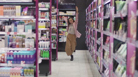 cheerful woman dancing in cosmetics store