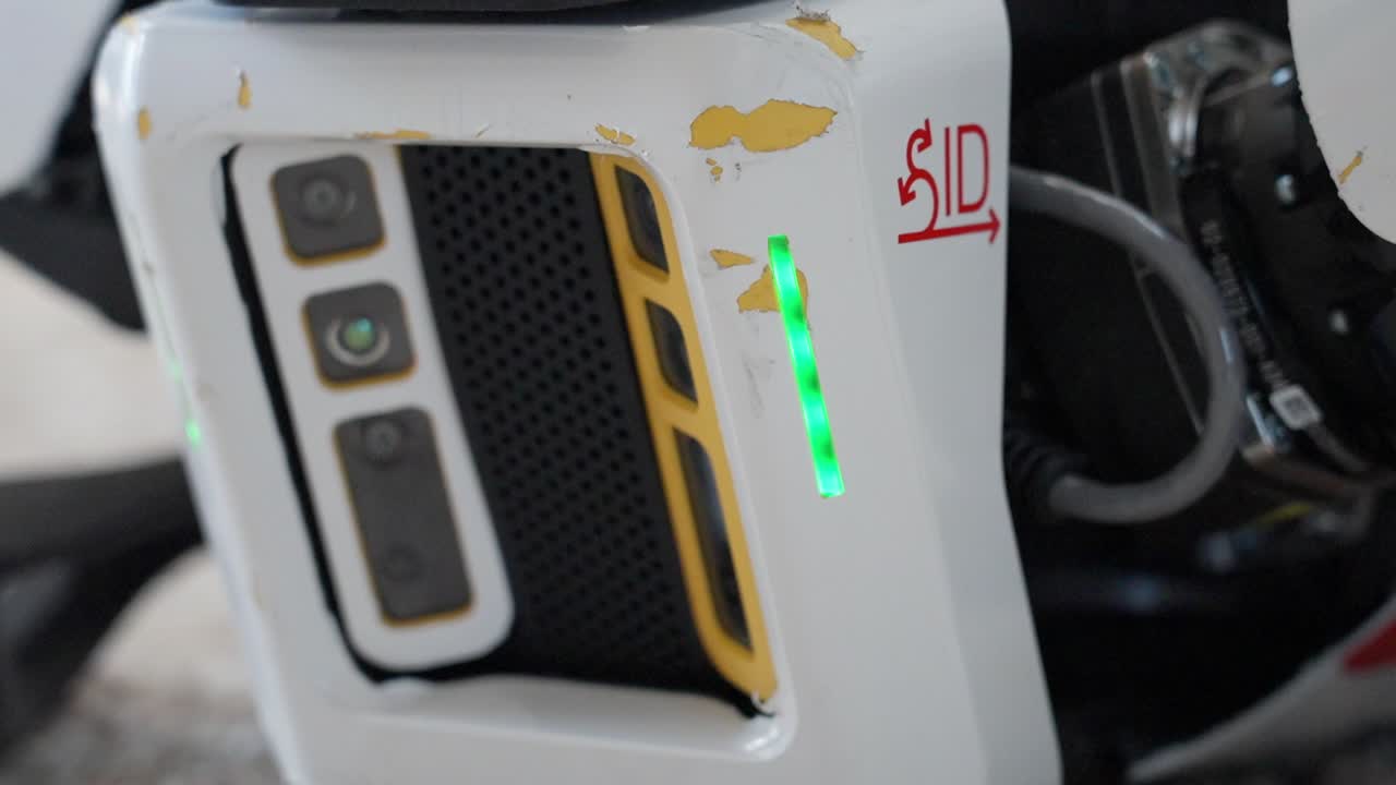 Close-up of a robotic dog camera sensor with visible wear marks and high-tech details