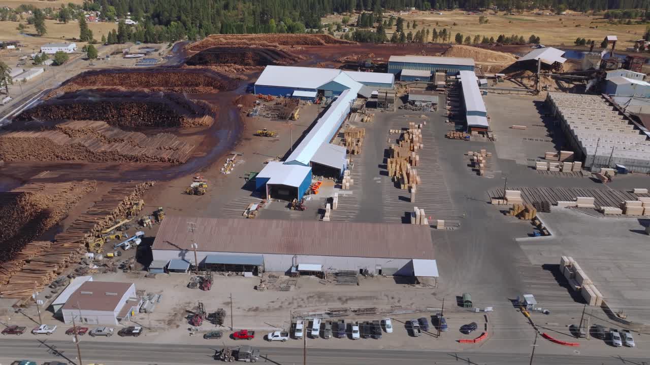 Aerial view of a large, busy industrial sawmill in operation