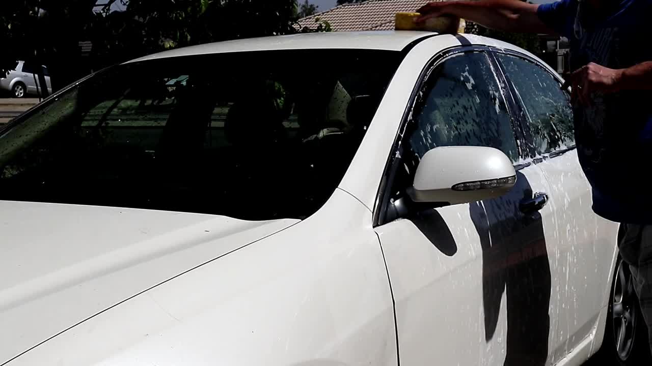 Man washing the roof of a car