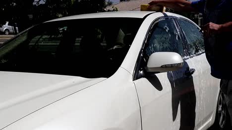 man washing the roof of a car