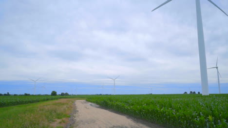 wind turbine farm. rural road between two farm fields with wind turbines