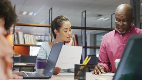 Diverse-male-and-female-business-colleagues-talking-and-taking-notes