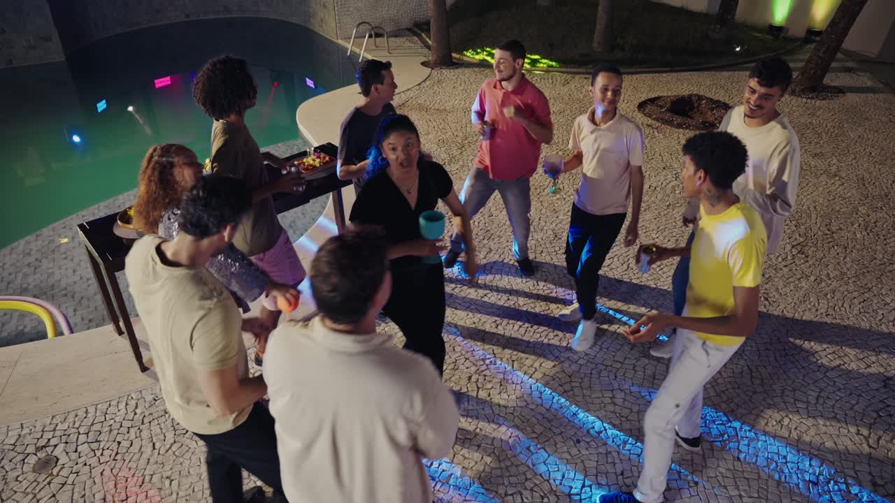 Group of Friends Enjoying a Night Party by the Swimming Pool