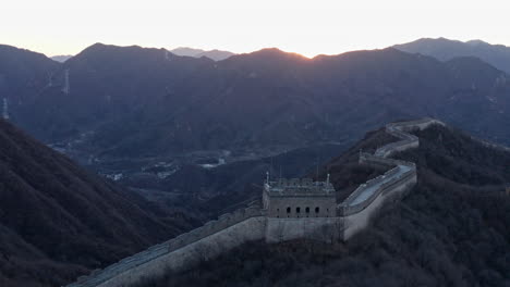 Aerial-Shot-of-Great-Wall-of-China-Winding-Through-Mountains-at-Sunset