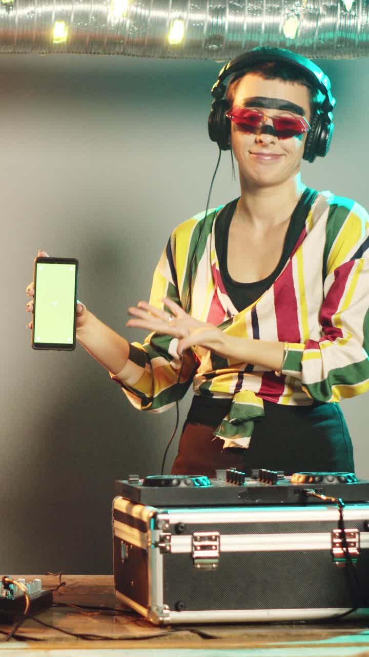 Artista DJ di video verticali mostra un modello di green screen mentre usa i giradischi