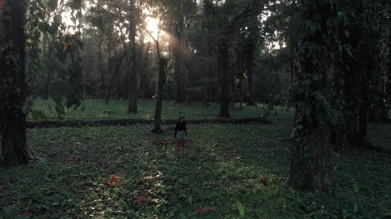 A beautiful lady standing in the middle of the lush, green jungle of Costa Rica - aerial