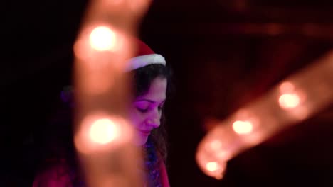 woman in santa hat with christmas lights
