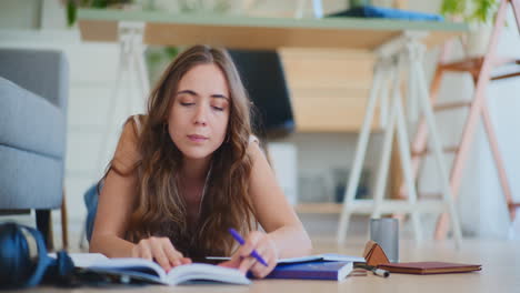 mujer estudiando en el suelo en casa