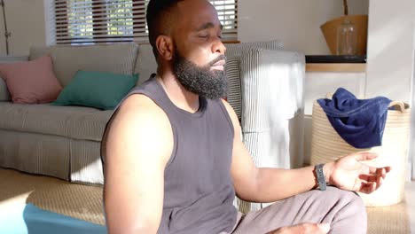 focused african american man doing yoga meditation at home, slow motion