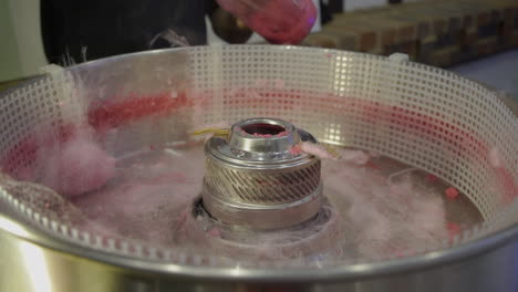 a spinning cotton candy sticking on the stick in the machine