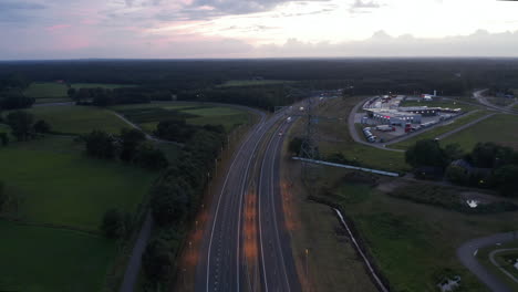 Tobogán-Aéreo-Sobre-La-Autopista-Europea-Al-Atardecer-Con-Tráfico-De-Automóviles