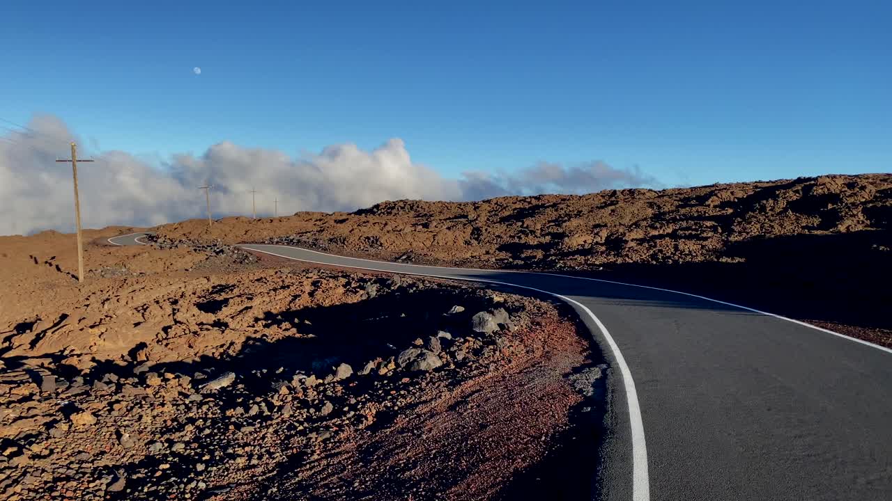 Sunset on Mauna Loa access road with telegraph poles and rising moon