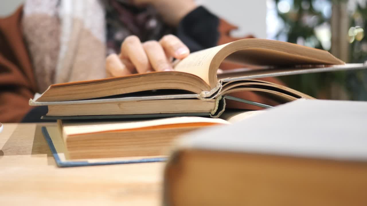 mujer leyendo libros en un café