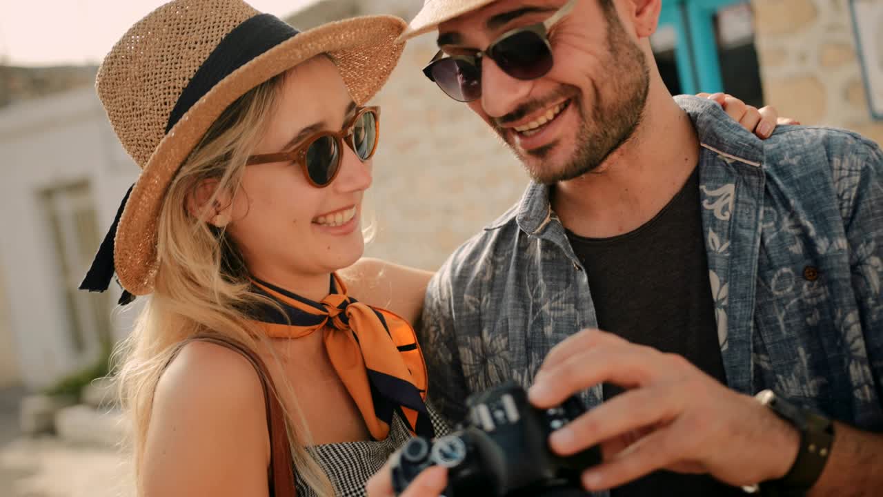 카메라 를 들고 사진 을 보는 관광객 부부