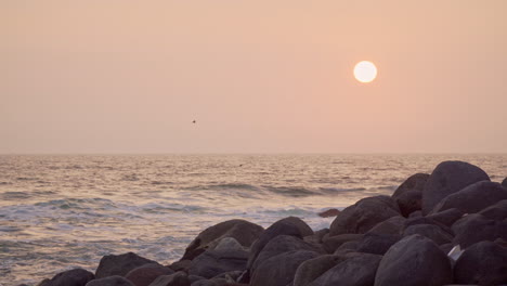 Static-sunset-shot-at-a-rocky-beach-along-the-coast-in-San-Bartolo,-Lima,-Peru