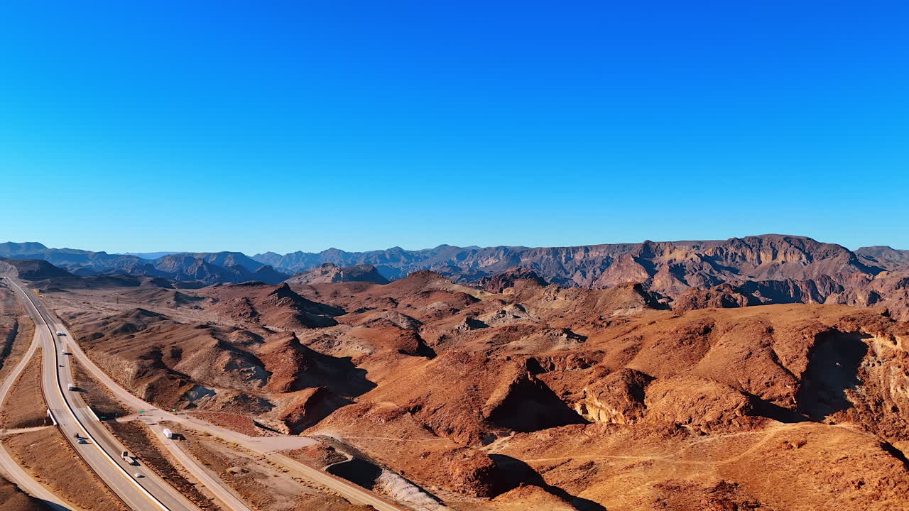 Vue sur les autoroutes dans le paysage rocheux aride. Logistique à travers la zone désertique de l’Arizona, États-Unis. Vidéo de drone
