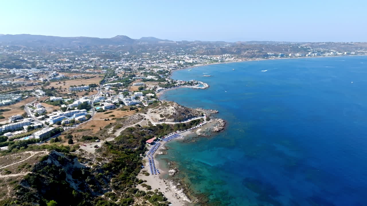 Aerial view of a beautiful coastline with blue sea, beach, and mountains