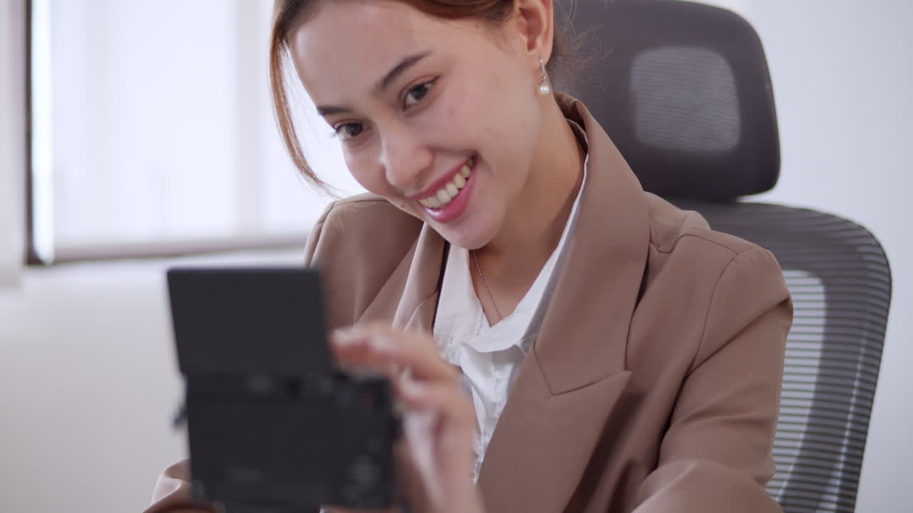 A woman influencer setting up her camera and waves to her followers and listeners online.