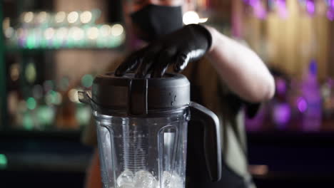 Bartender-using-blender-with-ice-cubes-cocktail-in-slow-motion