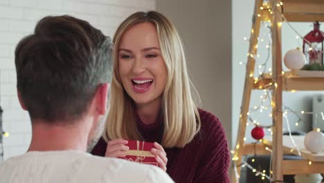 man giving his girlfriend the christmas present with love