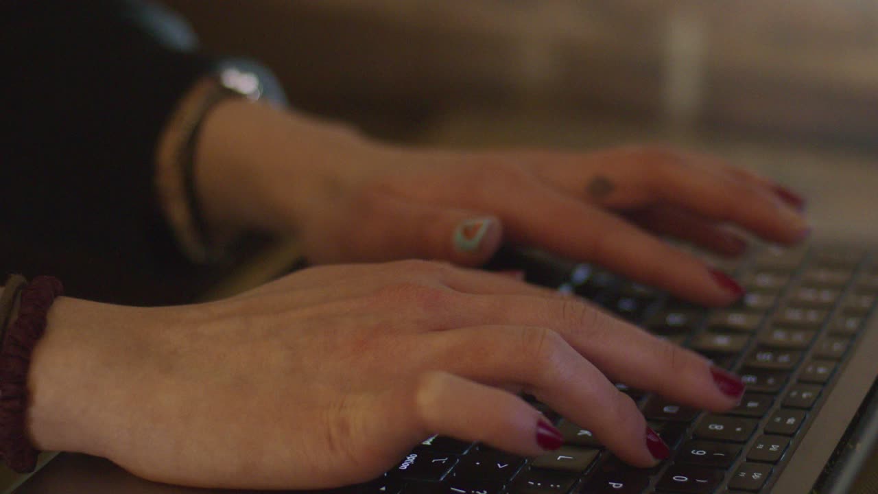 Female Typing on Macbook Laptop with Red Nails, finger tattoo and jewelry - Slow Motion