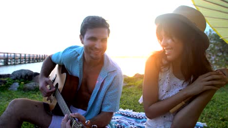 hombre y mujer multiétnicos con picnic en la playa