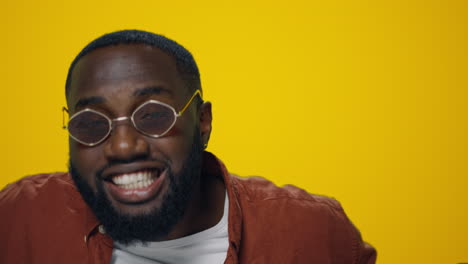 Closeup-happy-african-american-handsome-dancing-on-yellow-background.