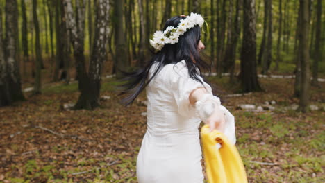 Kaukasische-Frau-Mittleren-Alters-Mit-Blumenkranz-Läuft-Im-Waldpark-Und-Blickt-In-Die-Kamera,-Um-Sich-Zu-Entspannen