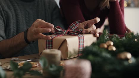 close up of couple packing christmas gift